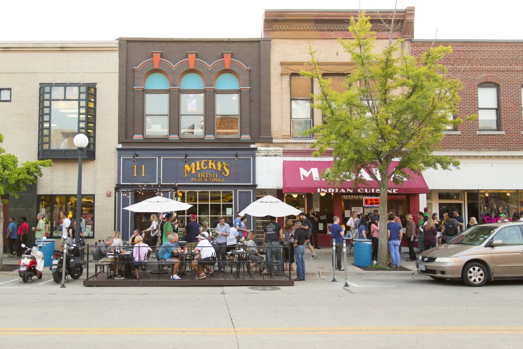 a group of people sitting at tables outside a restaurant